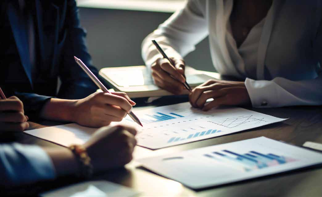 Profissionais analisam gráficos e relatórios em uma mesa de reunião