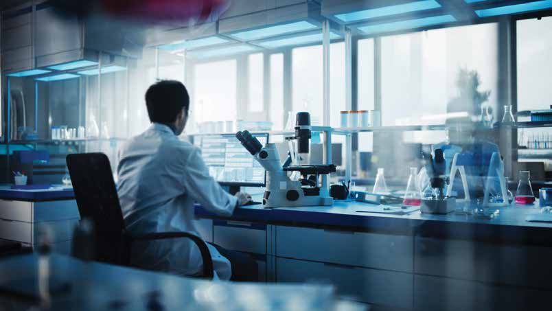 Pesquisador trabalha em uma bancada de laboratório com microscópio